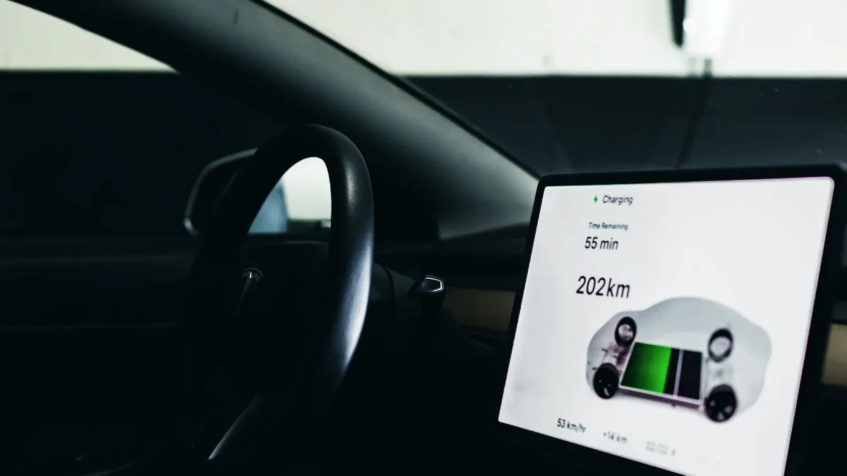 Mekaniker läser av batterihälsan på en elbil med en diagnosplatta i OBD-uttaget